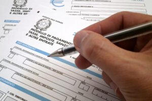 modulo f24 con penna e mani che compilano