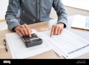 persona che utilizza calcolatrice e documenti