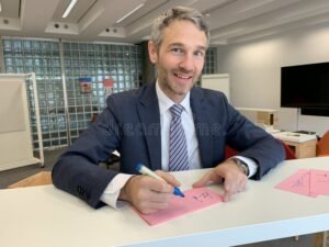 persona con tessera televisiva e documenti ufficiali