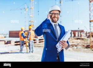 uomo daffari con casco e planimetrie in cantiere